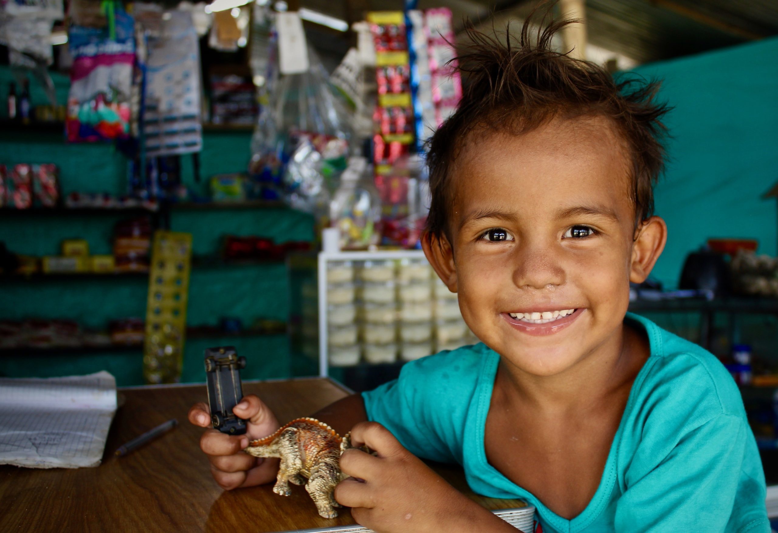Gabriel smiler stort mens han leger med sin yndlings dinosaurus