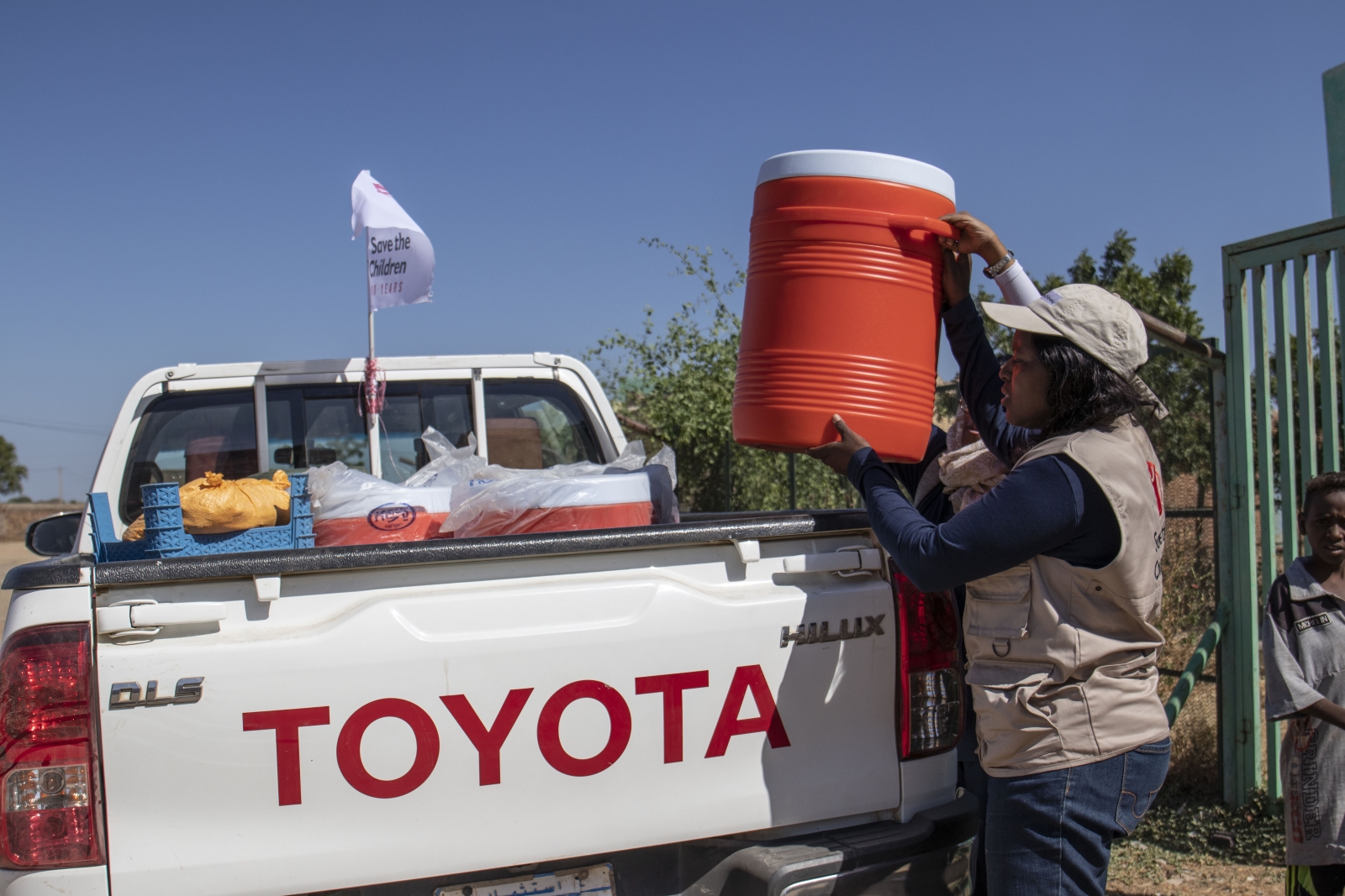 Sarah fylder sin ladbil med beholder med rent vand og sanitære produkter, der skal destribueres til de forskellige vaccinationsklinikker.