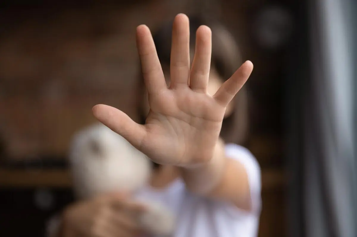 Barn holder hånd frem foran ansigt