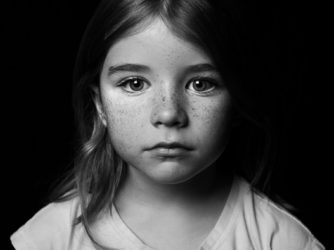 Portræt af en ung pige med et udtryksløst ansigt