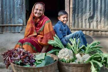 Dreng og hans mor har høstet grøntsager i Bangladesh
