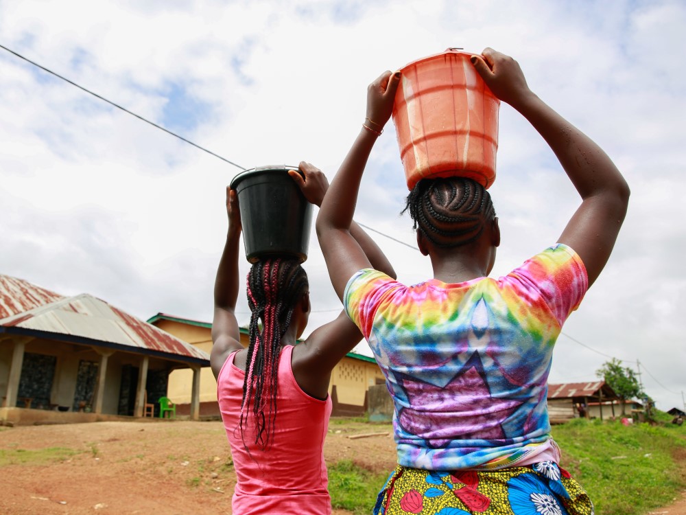 Piger bærer vand hjem i Sierra Leone