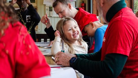 Frivillig og børn rundt om et bord
