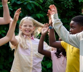 En gruppe børn giver hinanden highfives