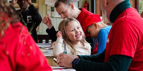 Frivillig og boern sidder ved et bord