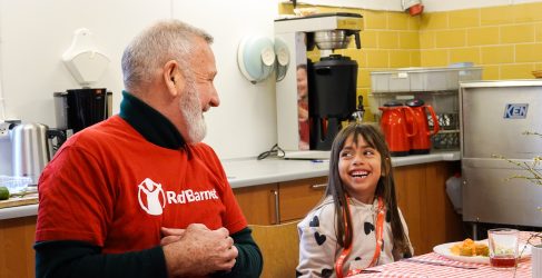 Voksen og barn med mad ved spisebord