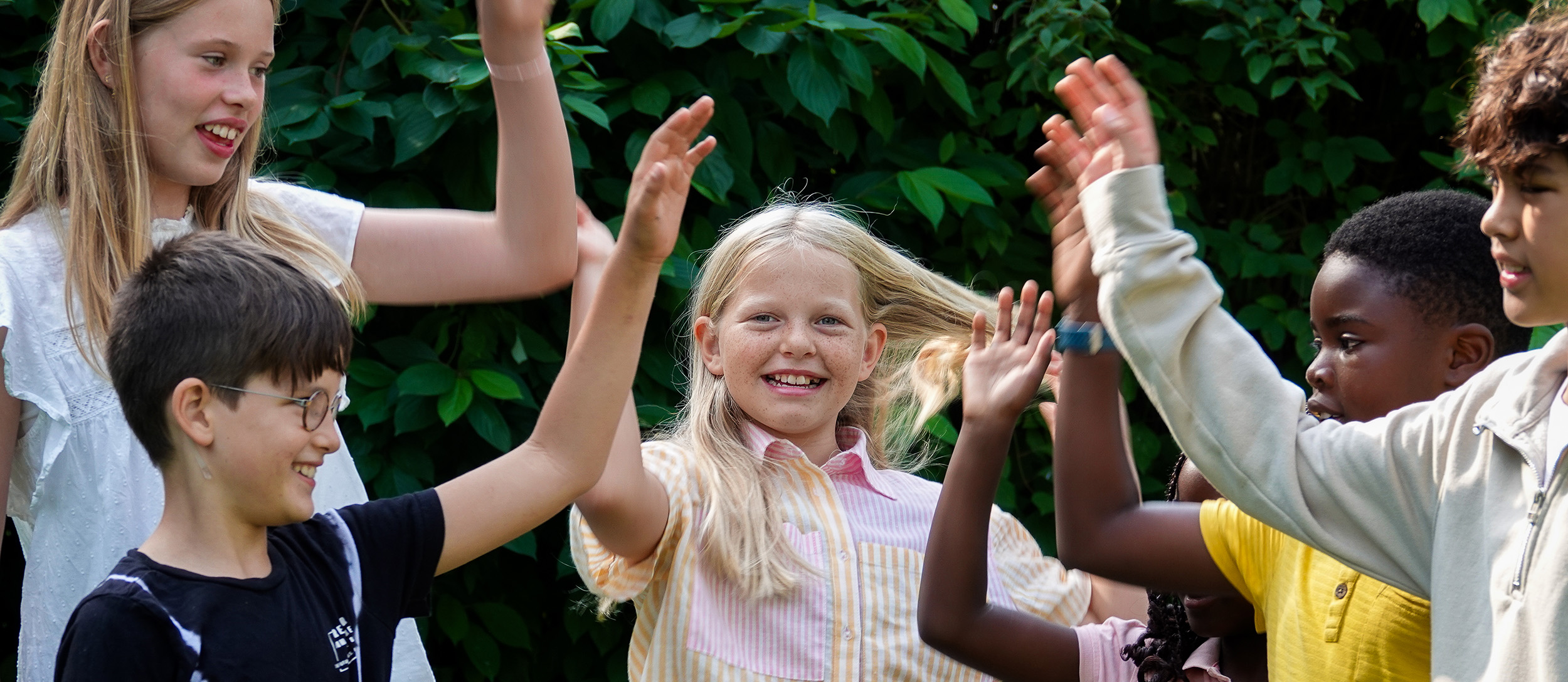 Seks børn highfiver udendørs